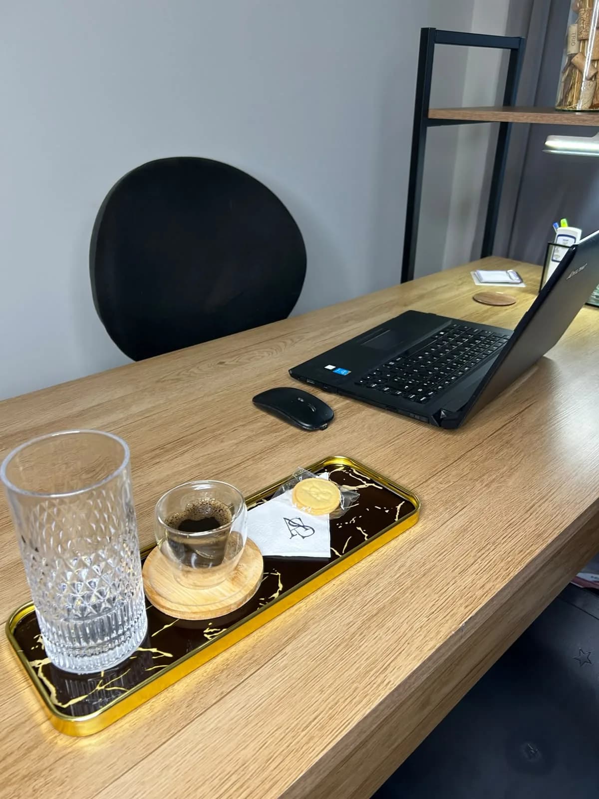 Bandeja de boas-vindas na mesa de atendimento, com água, café e biscoito